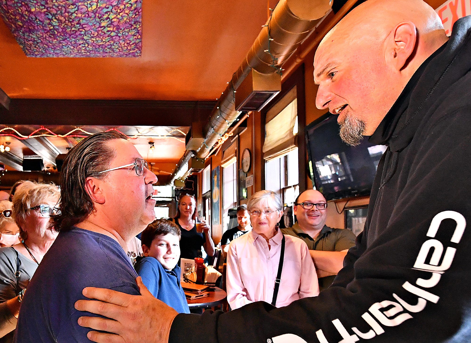 Fred Wallick, left, of Dover Township, greets Lt. Gov. John Fetterman during a campaign stop at Holy Hound Taproom in York City, Thursday, May 12, 2022. Fetterman is a candidate for U.S. Senate. Dawn J. Sagert photo