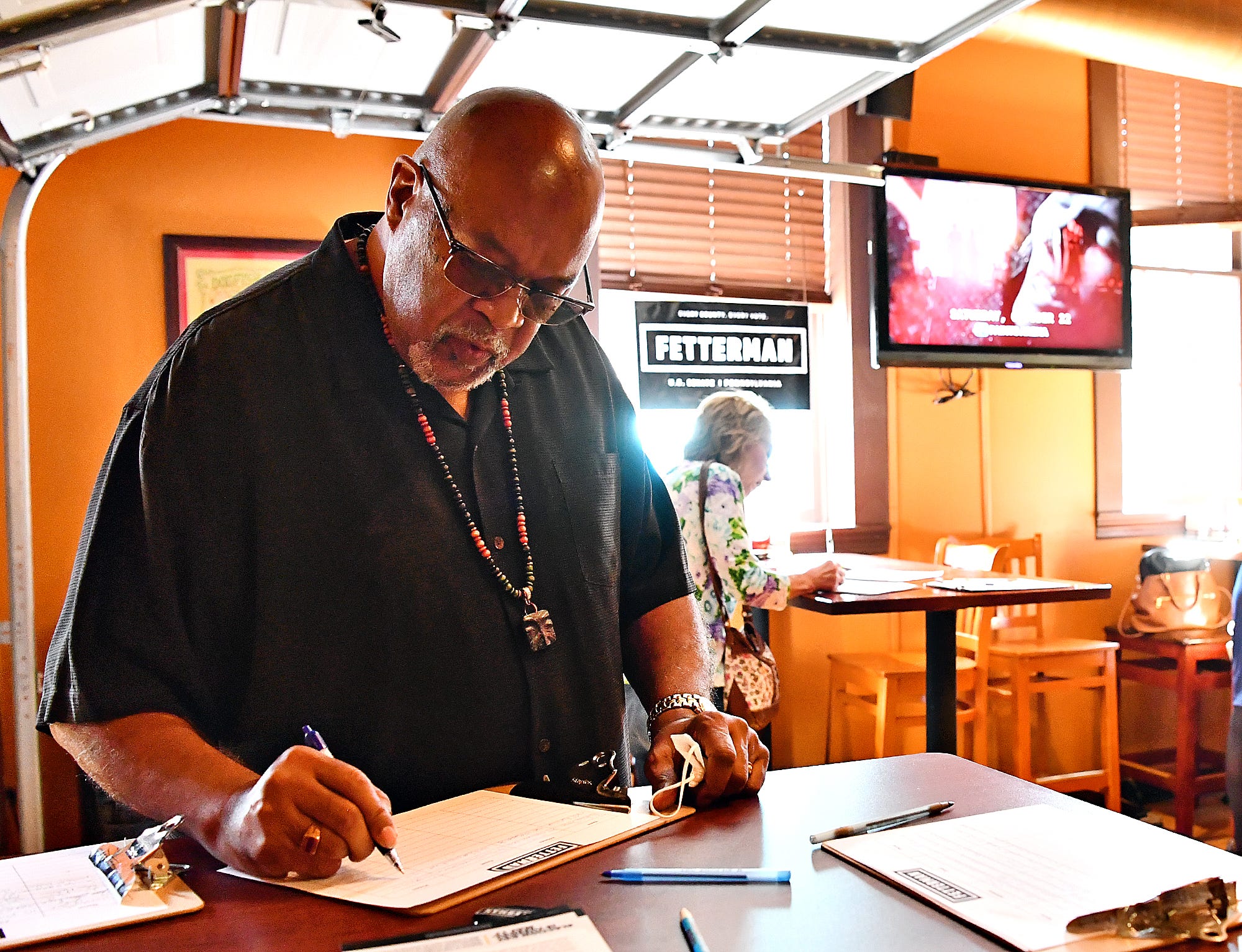 Jeff Kirkland, of York City, signs in before Lt. Gov. John Fetterman makes a campaign stop for U.S. Senate at Holy Hound Taproom in York City, Thursday, May 12, 2022. Kirkland is chair of the Lebanon Cemetery board of directors and serves as research director of the York African-American Historical Preservation Society. Dawn J. Sagert photo