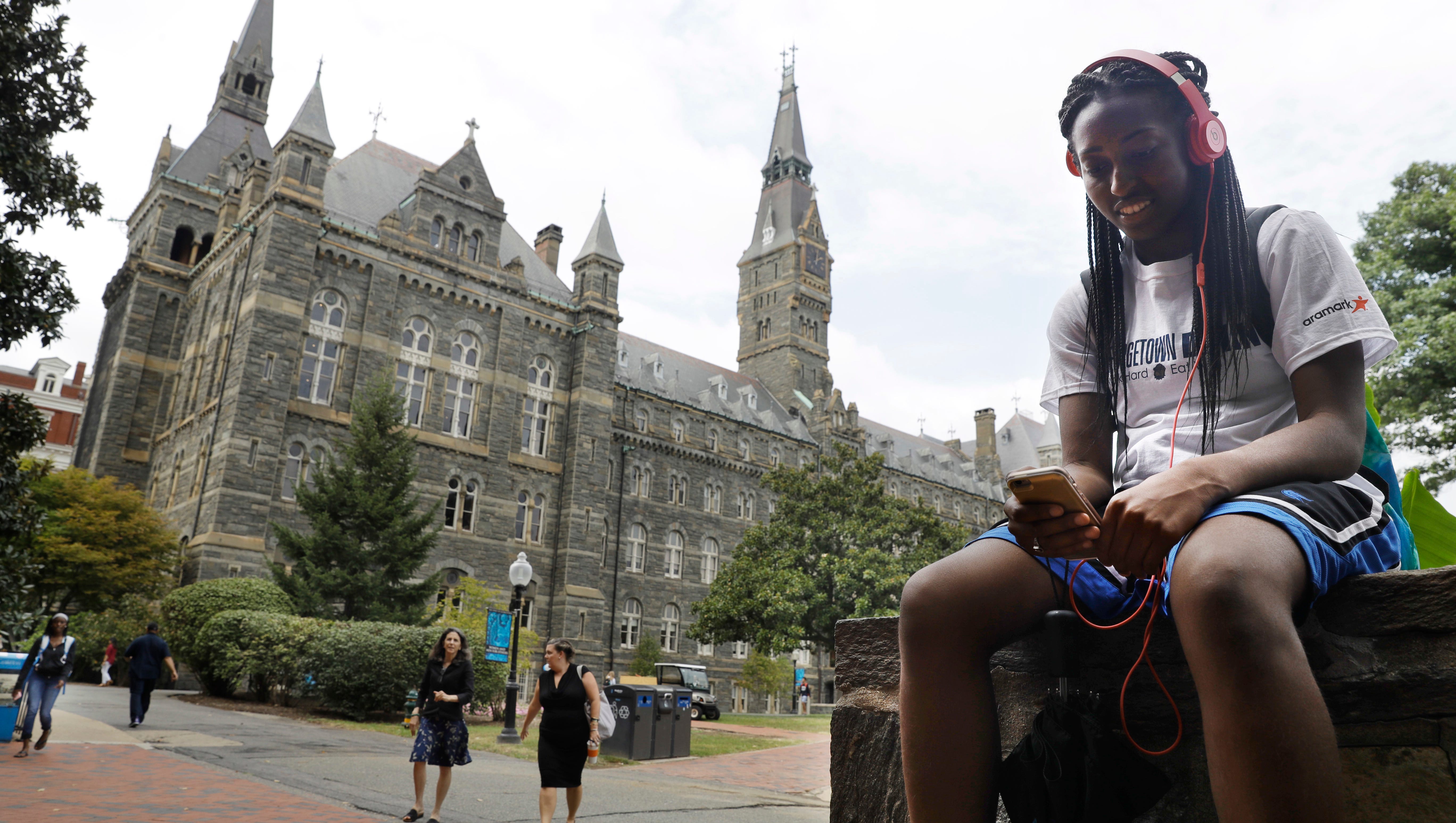Deja Lindsey, 20, a junior at Georgetown University, talks on her cell phone in front of Healy Hall on campus, Thursday, Sept. 1, 2016, in Washington. After renaming the Mulledy and McSherry buildings at Georgetown University temporarily to Freedom Hall and Remembrance Hall, Georgetown University will give preference in admissions to the descendants of slaves owned by the Maryland Jesuits as part of its effort to atone for profiting from the sale of enslaved people. Georgetown president John DeGioia announced Thursday that the university will implement the admissions preferences. The university released a report calling on its leaders to offer a formal apology for the university's participation in the slave trade.  (AP Photo/Jacquelyn Martin)