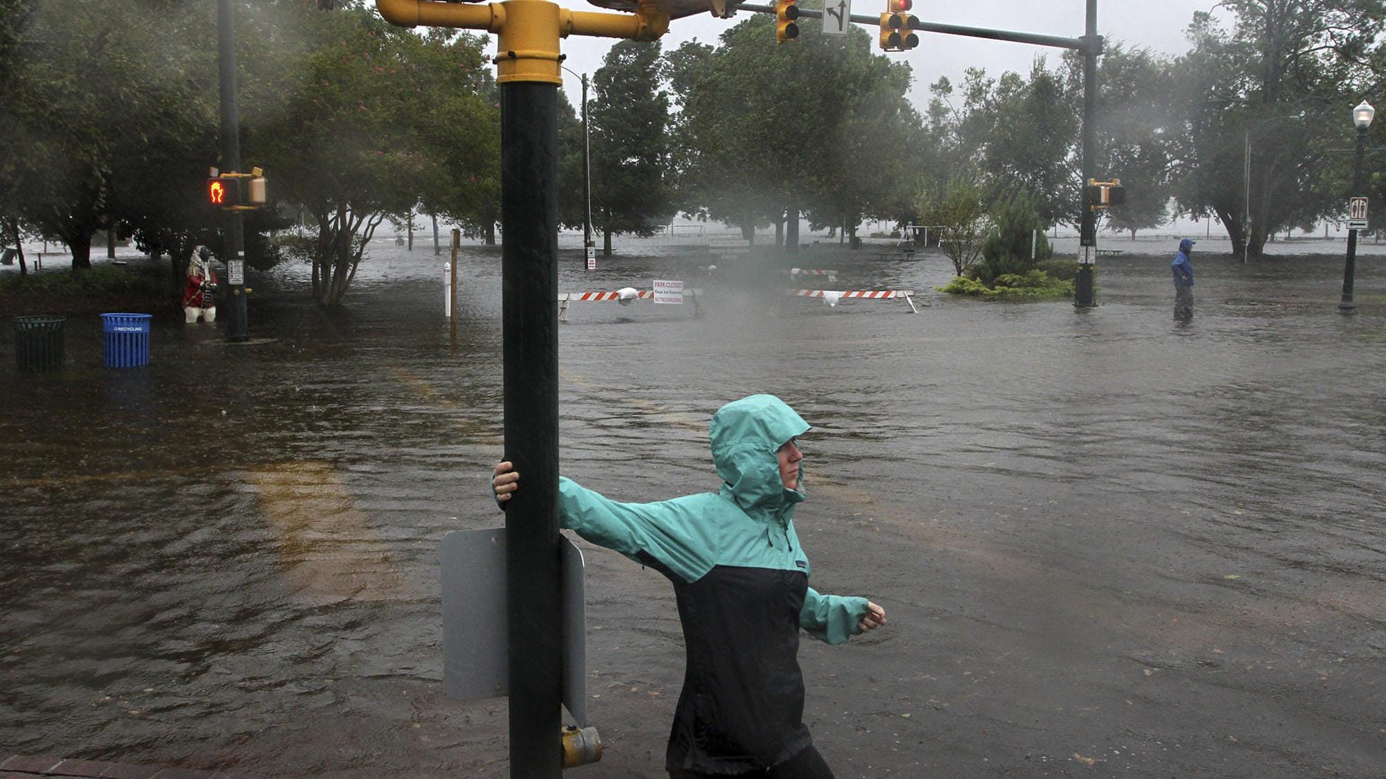 Jamie Thompson walks through flooded sections of East Front Street near Union Point Park in New Bern, N.C. Thursday, Sept. 13, 2018. Hurricane Florence already has inundated coastal streets with ocean water and left tens of thousands without power, and more is to come. (Gray Whitley/Sun Journal via AP)