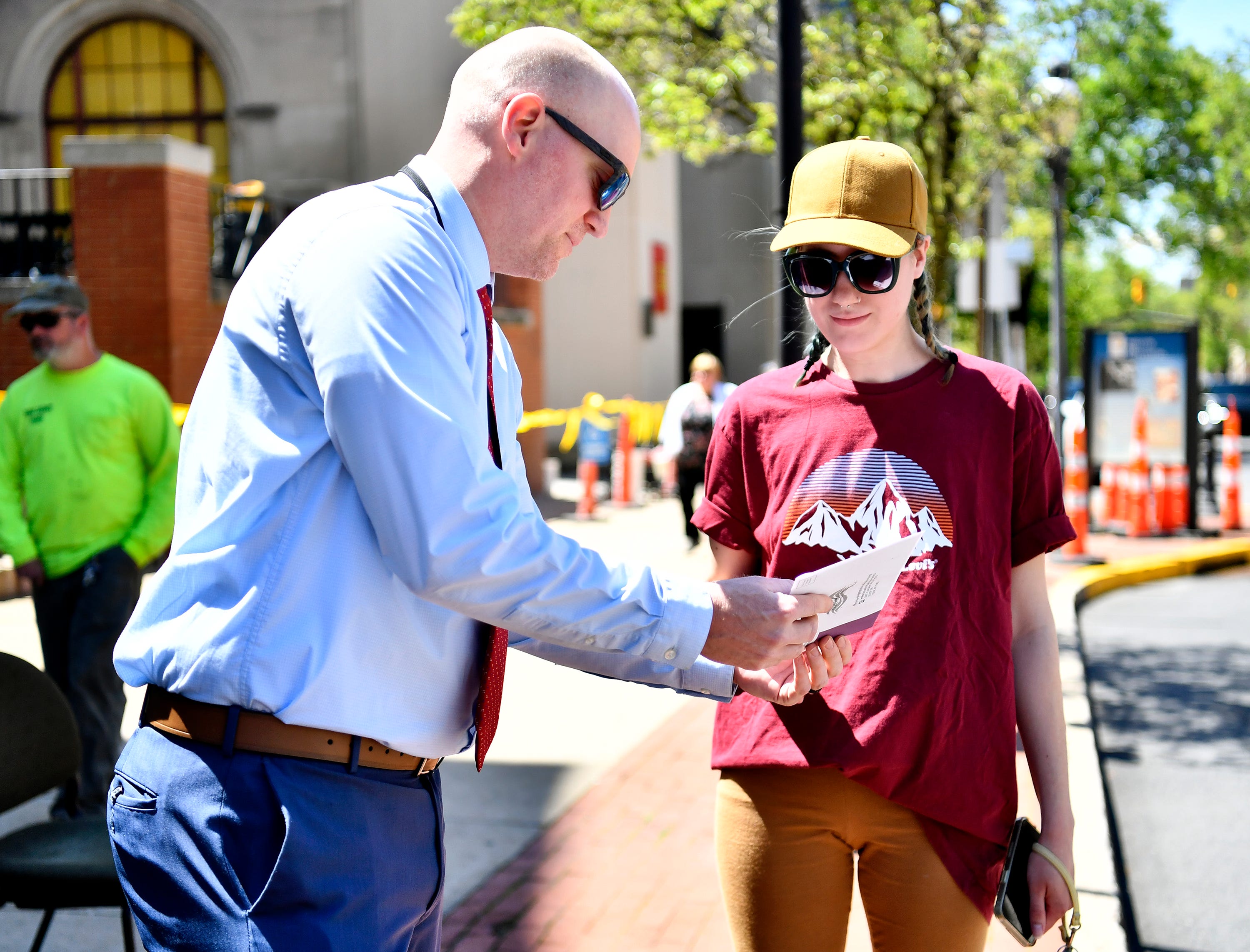 York County Prison Warden Adam Ogle, left, receives ballot being dropped off by Kayleigh Johnson, of York City, at the secured drop box in front of the York County Administrative Center on East Market Street in York City during Primary Election Day, Tuesday, April 23, 2024. (Dawn J. Sagert/The York Dispatch)