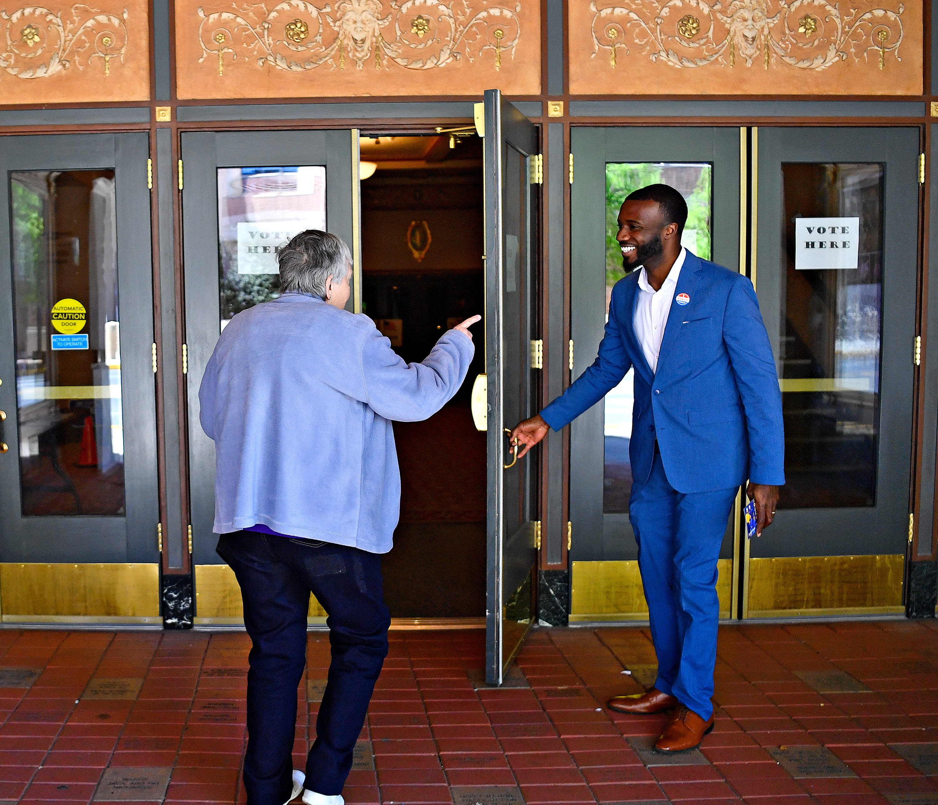 Blake Lynch, right, Democratic candidate for the 10th Congressional District, holds the door for voter Anna Wagner, of York City, before she casts her vote at the Appell Center for the Performing Arts during Primary Election Day in York City, Tuesday, April 23, 2024. (Dawn J. Sagert/The York Dispatch)