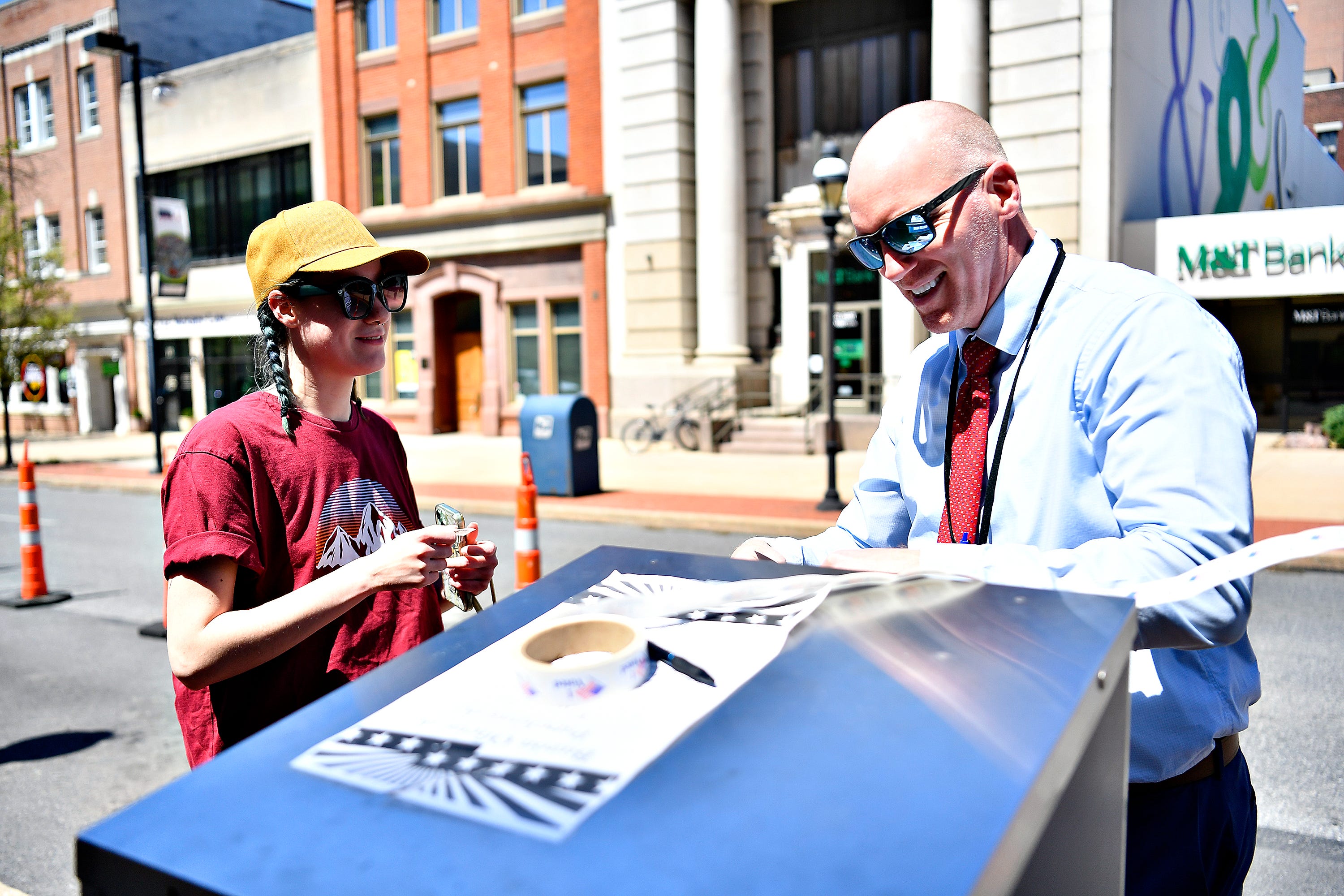Kayleigh Johnson, left, of York City, looks on as York County Prison Warden Adam Ogle, drops Johnson’s ballot into a secured drop box in front of the York County Administrative Center on East Market Street in York City during Primary Election Day, Tuesday, April 23, 2024. (Dawn J. Sagert/The York Dispatch)