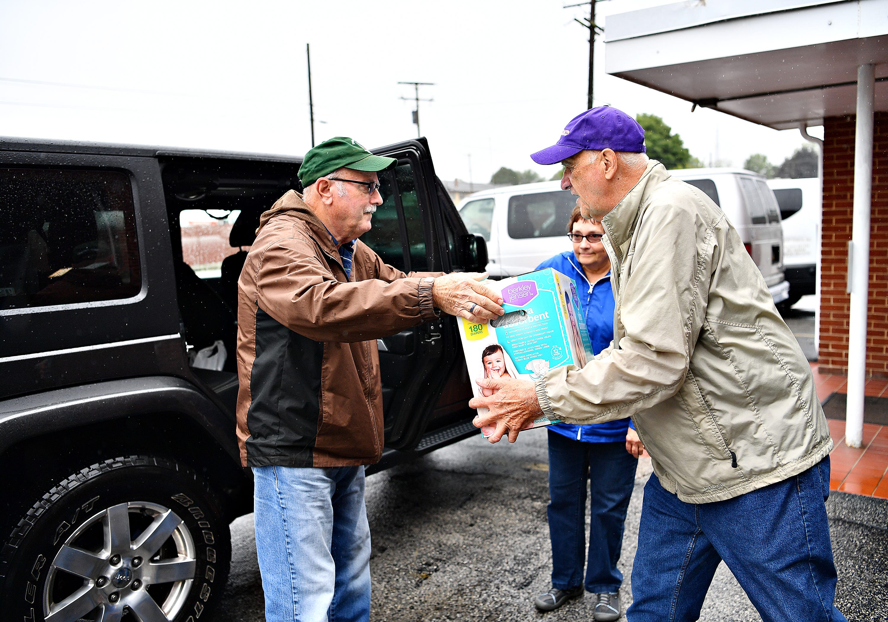 Fred Noble, front right, of Bailey Coach, receives a donation from Dennis Delp, left, and Linda Delp, both of West Manchester Township, at Bailey Coach in West Manchester Township, Tuesday, Sept. 11, 2018. The items collected will be delivered to areas that are projected to be in the path of Hurricane Florence. Dawn J. Sagert photo