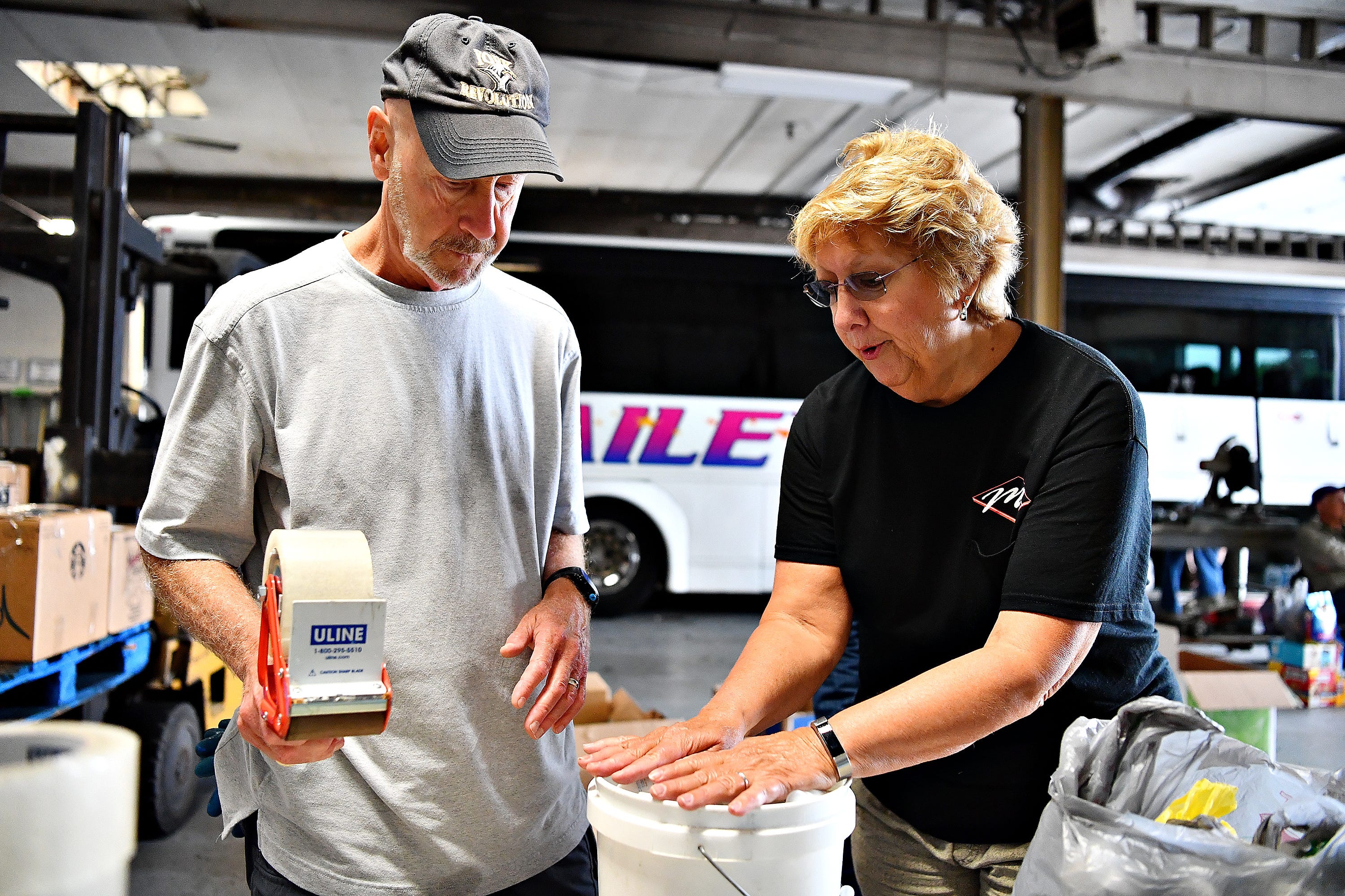 Don Reichard, left, of West Manchester Township, and Jane Bailey, of Spring Grove, discuss how they will secure items in a bucket as donations of non-perishable items and toiletries are collected at Bailey Coach in West Manchester Township, Tuesday, Sept. 11, 2018. The items will be delivered to areas that are projected to be in the path of Hurricane Florence. Dawn J. Sagert photo