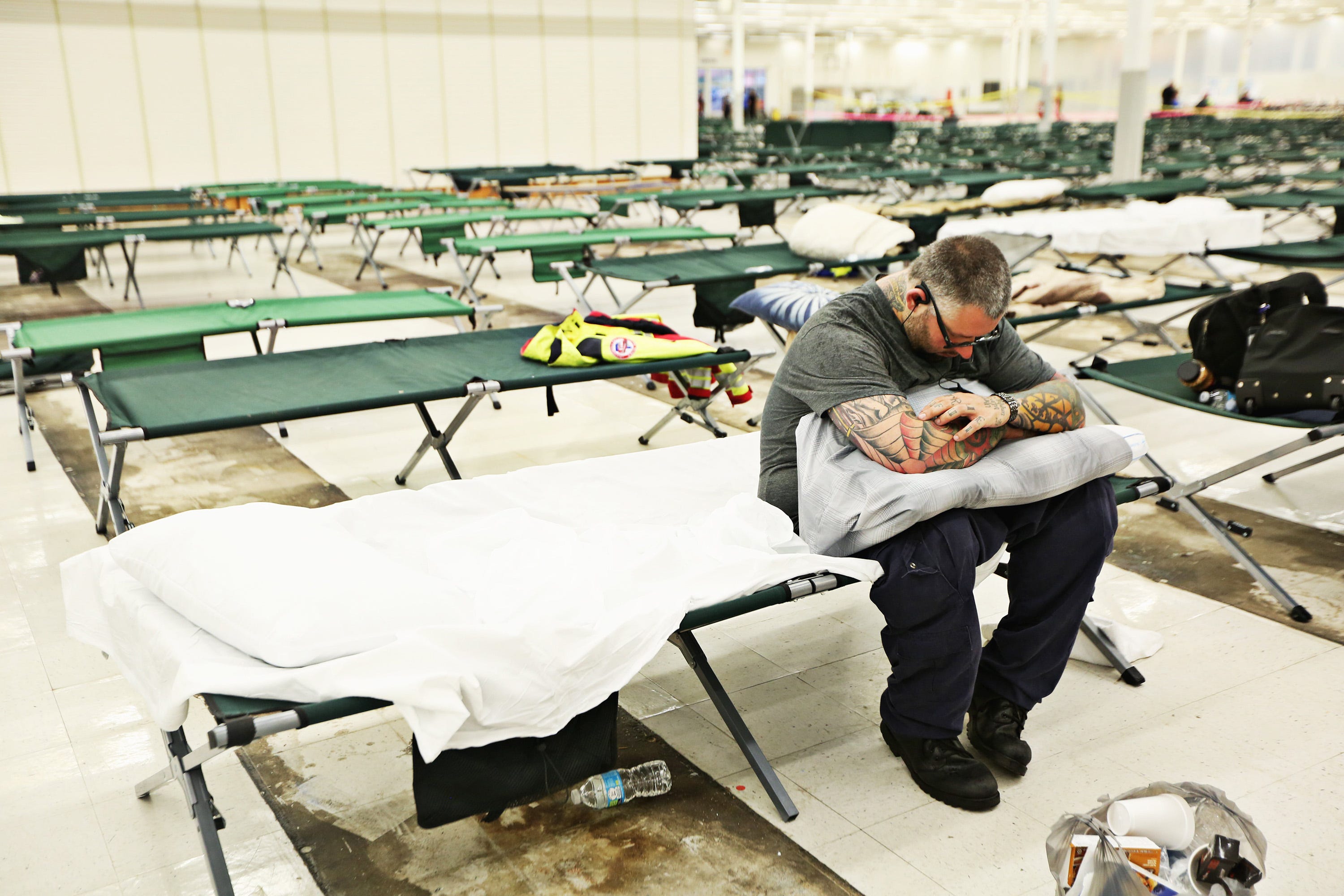 Raffi Hovsepian, a critical care paramedic with All County Ambulance, plugs in earbuds and tries to relax Friday morning, Sept. 14, 2018, in an old Kmart in Garner used as a makeshift shelter for first responders traveling to the state from other areas to wait for assignments to help with Hurricane Florence. Hovsepian travelled with a crew of four men from Ft. Pierce, Fla. (Juli Leonard/The News & Observer/TNS)