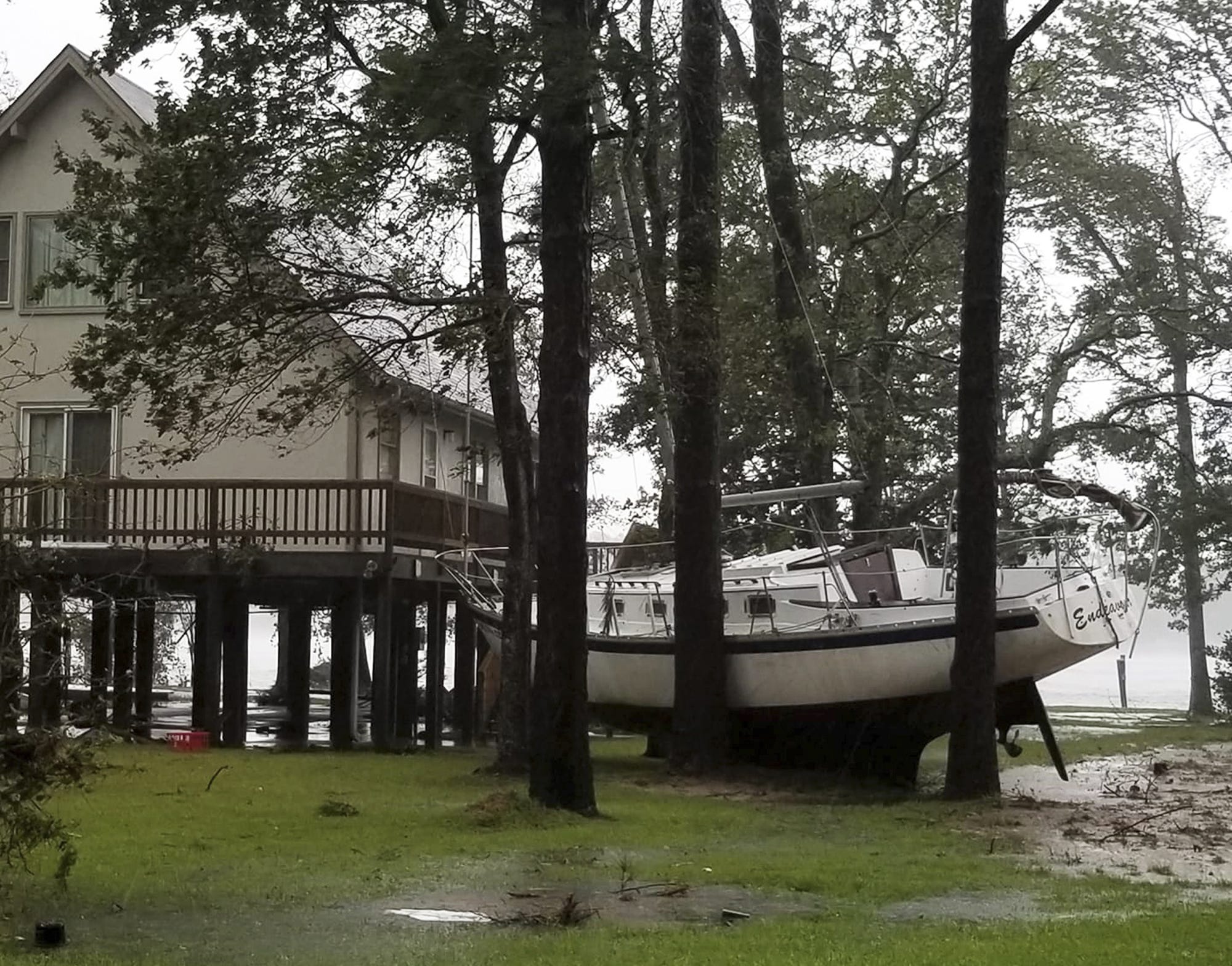 This photo provided by Angie Propst, shows a boat wedged in trees during Hurricane Florence in Oriental, N.C, one of nine incorporated municipalities in Pamlico County, Friday, Sept. 14, 2018.   (Angie Propst via AP)