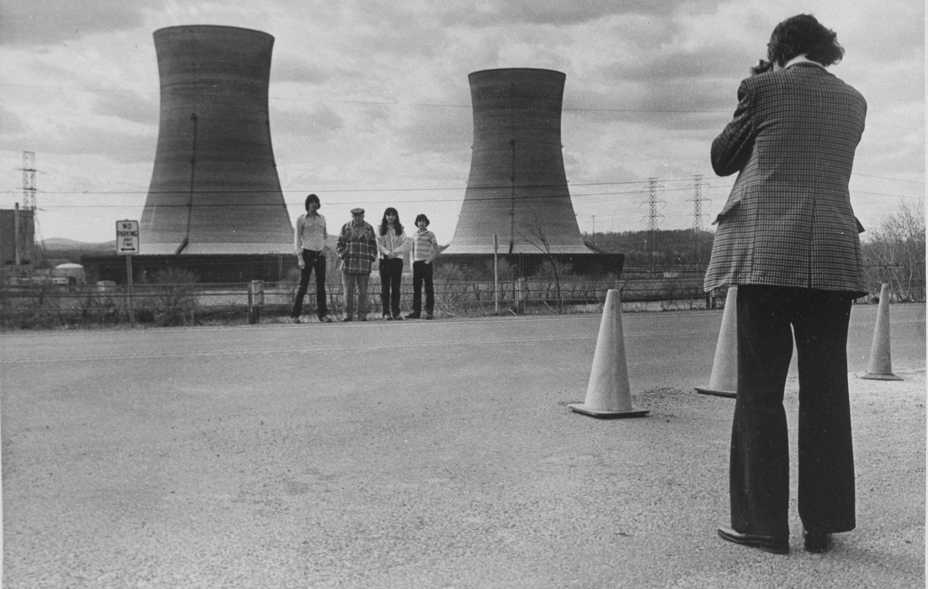 A group of tourists have their photograph taken by a family member as they pose with cooling towers from Three Mile Island nuclear power plant near Middletown, Pa., May 11, 1979. (AP Photo/Fred Prouser)