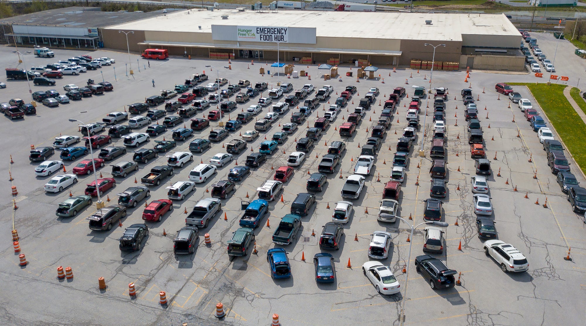 Hundreds of vehicles wait to pick up food during distribution at the East York Food Hub,  Tuesday, April 14, 2020. Hundreds of other vehicles waiting for the distribution were guided through a nearby neighborhood by fire police and Springettsbury Township Police to keep traffic flowing.
John A. Pavoncello photo