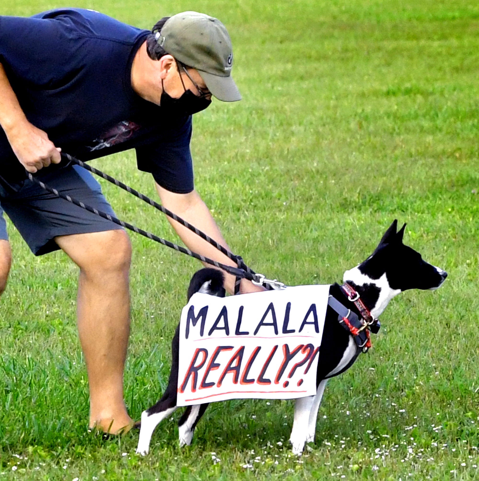 Tom Rayburn outfitted his dog Jagger with a sign referencing Pakistani activist Malala Yousafzai during a rally outside the Central York School District Administration offices before a school board meeting there Monday, Sept. 20, 2021. Rayburn's wife is a teacher in the district. The rally was in opposition to a banned resource list instituted by the district, which demonstrators say targets minority authors. District officials added formal discussion of the ban to Monday's agenda. Bill Kalina photo