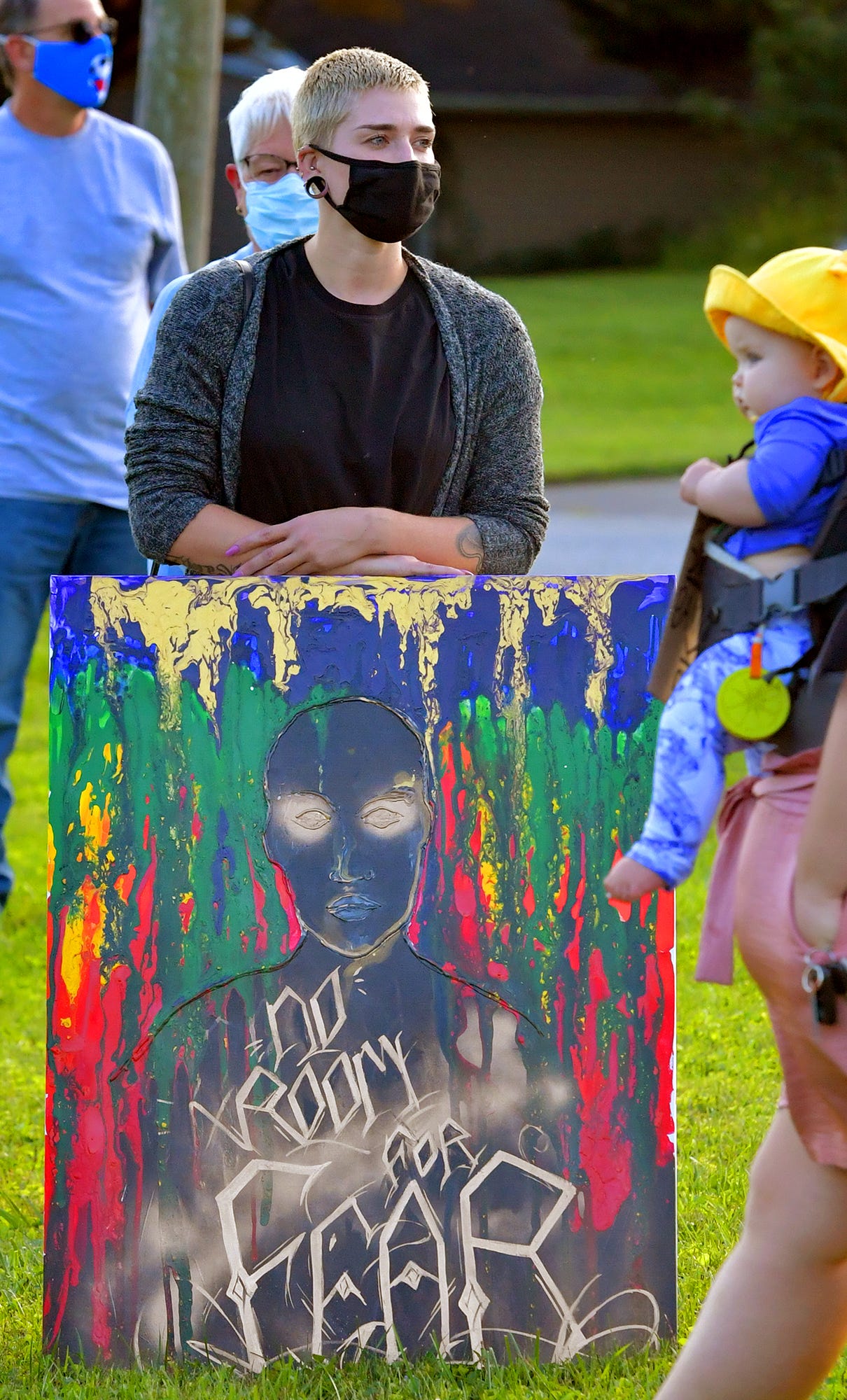 Central York School District art teacher Nicole Osborne displays an original piece of artwork during a rally outside the Central York School District Administration offices before a school board meeting there Monday, Sept. 20, 2021. The rally was in opposition to a banned resource list instituted by the district, which demonstrators say targets minority authors. District officials added formal discussion of the ban to Monday's agenda. Bill Kalina photo
