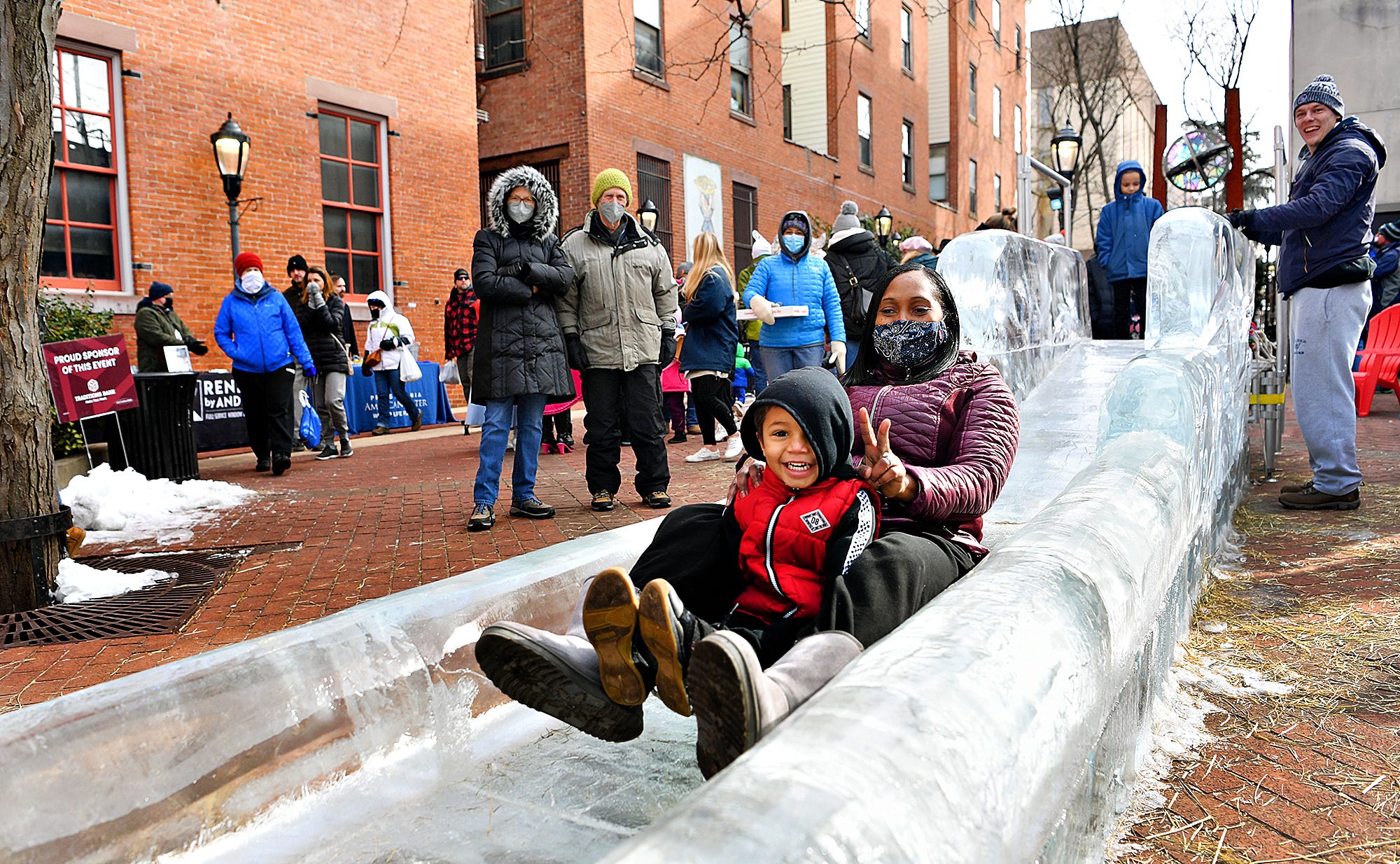 Brisa Dean, of York City, slides down the 40-foot WellSpan Ice Slide with her foster son, William, 3, during the 8th annual FestivICE event in downtown York City, Saturday, Jan. 15, 2022. Dawn J. Sagert photo