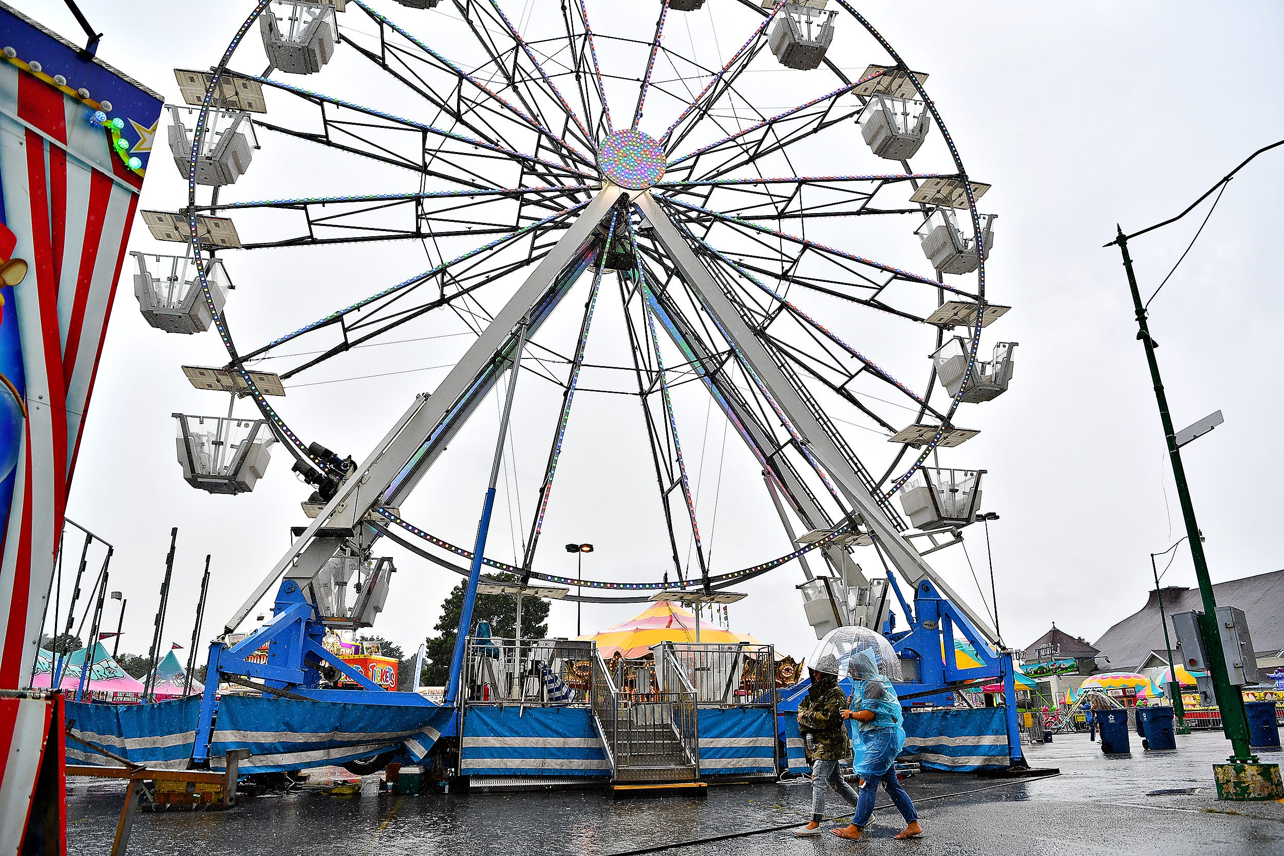 Patrons try to stay dry during the final day of York State Fair in York, Pa., Sunday, July 31, 2022. Dawn J. Sagert/The York Dispatch