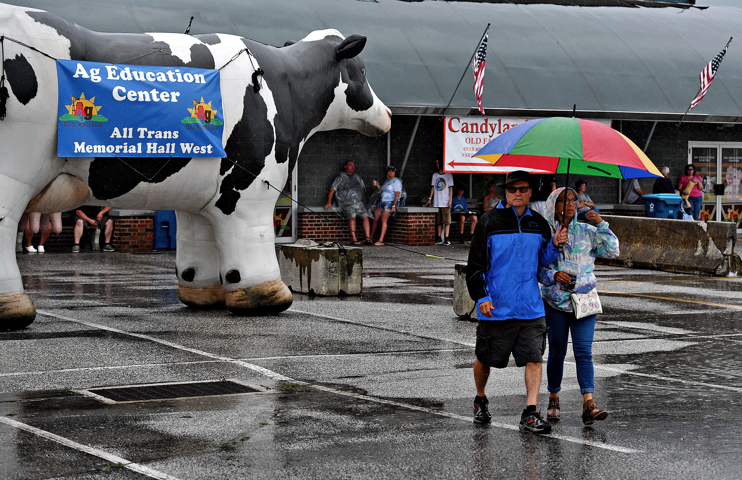 From right, Arlett Wood and Turk Fleagle, both of Red Lion, brave the rain during the final day of York State Fair in York, Pa., Sunday, July 31, 2022. Dawn J. Sagert/The York Dispatch