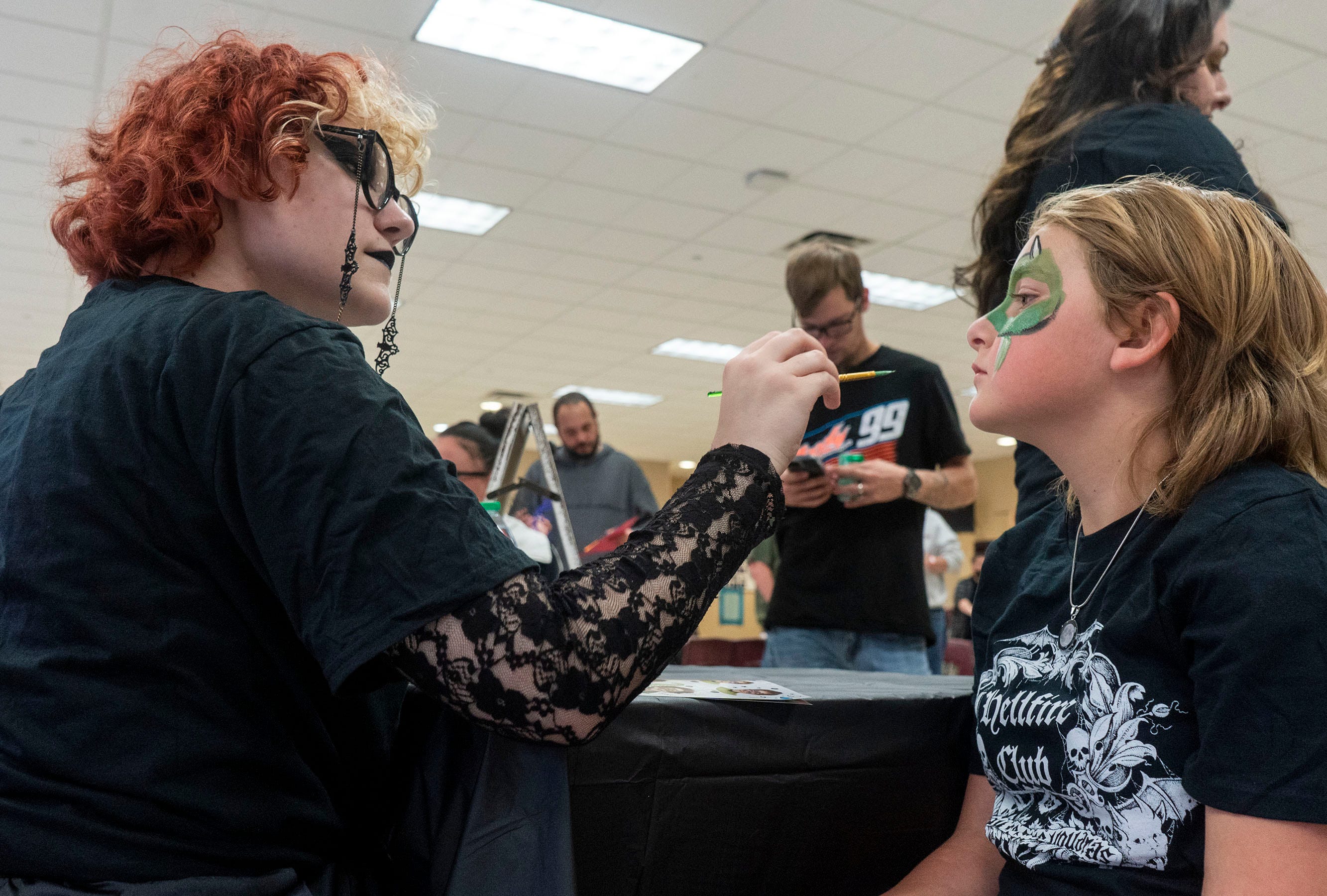 Elizabeth Bradley, on left, from Harleysville, painting Yardley Sipe's face (10), from Marietta, at the Satanic Temple's back to school event at Northern High School in Dillsburg on Saturday, Sept. 24, 2022.