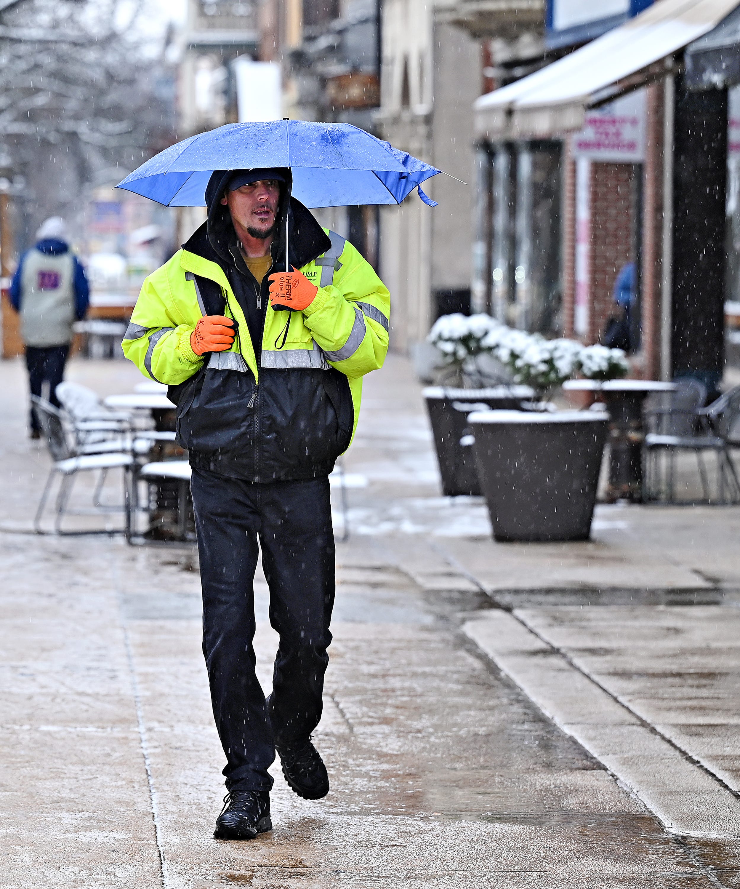 Brian Runkle, of York City, walks under an umbrella as snow turns to rain in York City, Wednesday, Jan. 25, 2023. Dawn J. Sagert photo